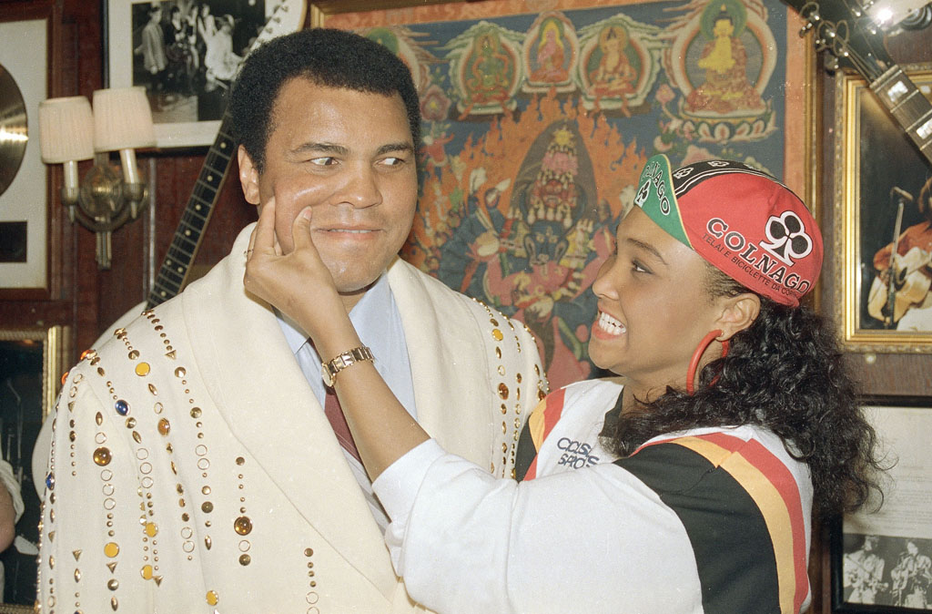 Muhammad Ali gets a pinch to the cheek from his 18-year-old daughter Maryum "May May" Ali at the Hard Rock Cafe in New York, May 12, 1988. The fighter presented the cafe with a boxing robe given to him by Elvis Presley. (AP Photo/Richard Drew)
